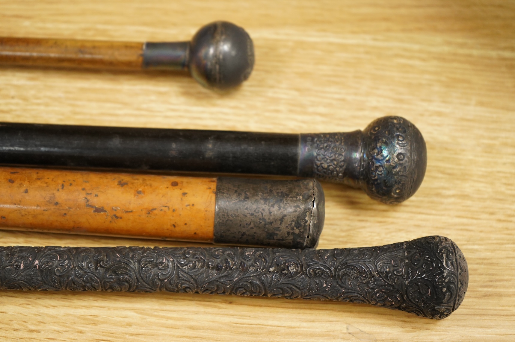 Three silver topped walking canes and a similar parasol, largest 97cm in length